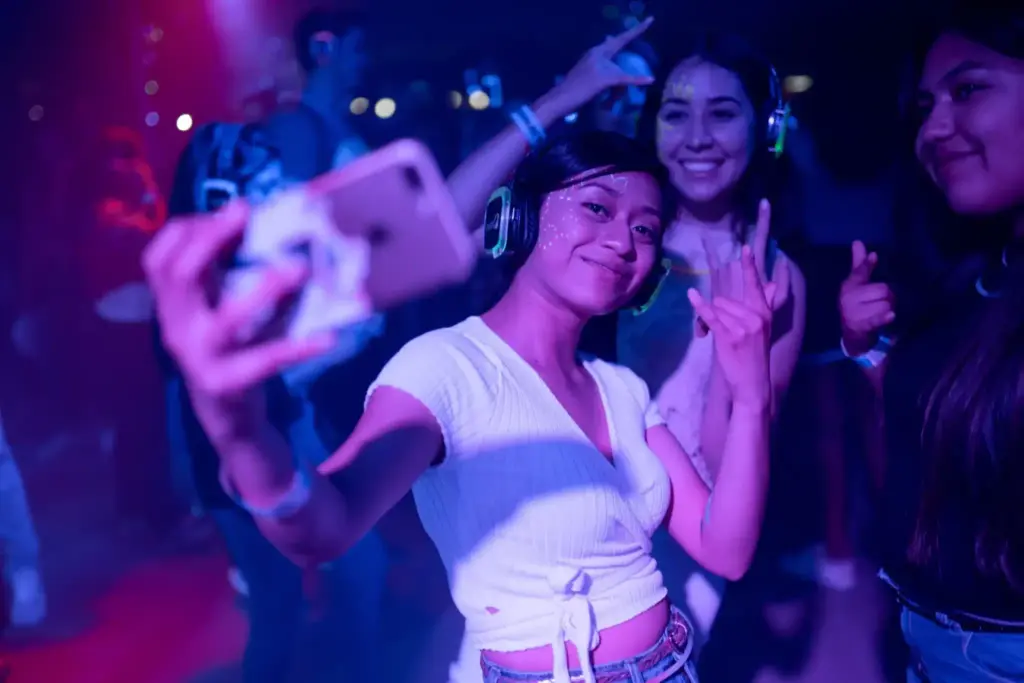 photo of a girl taking a selfie with friends while wearing headsets at a silent disco
