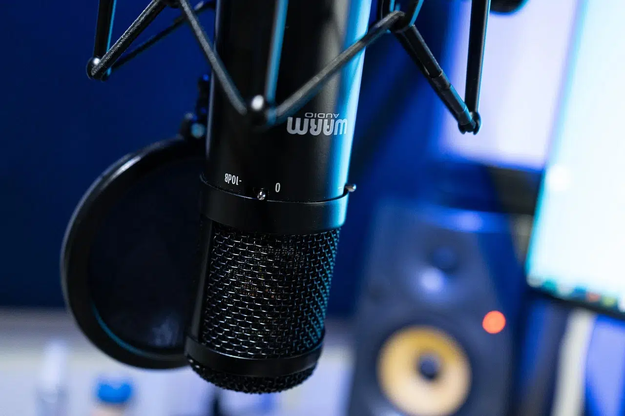 Photo of a microphone in front of a computer setup.