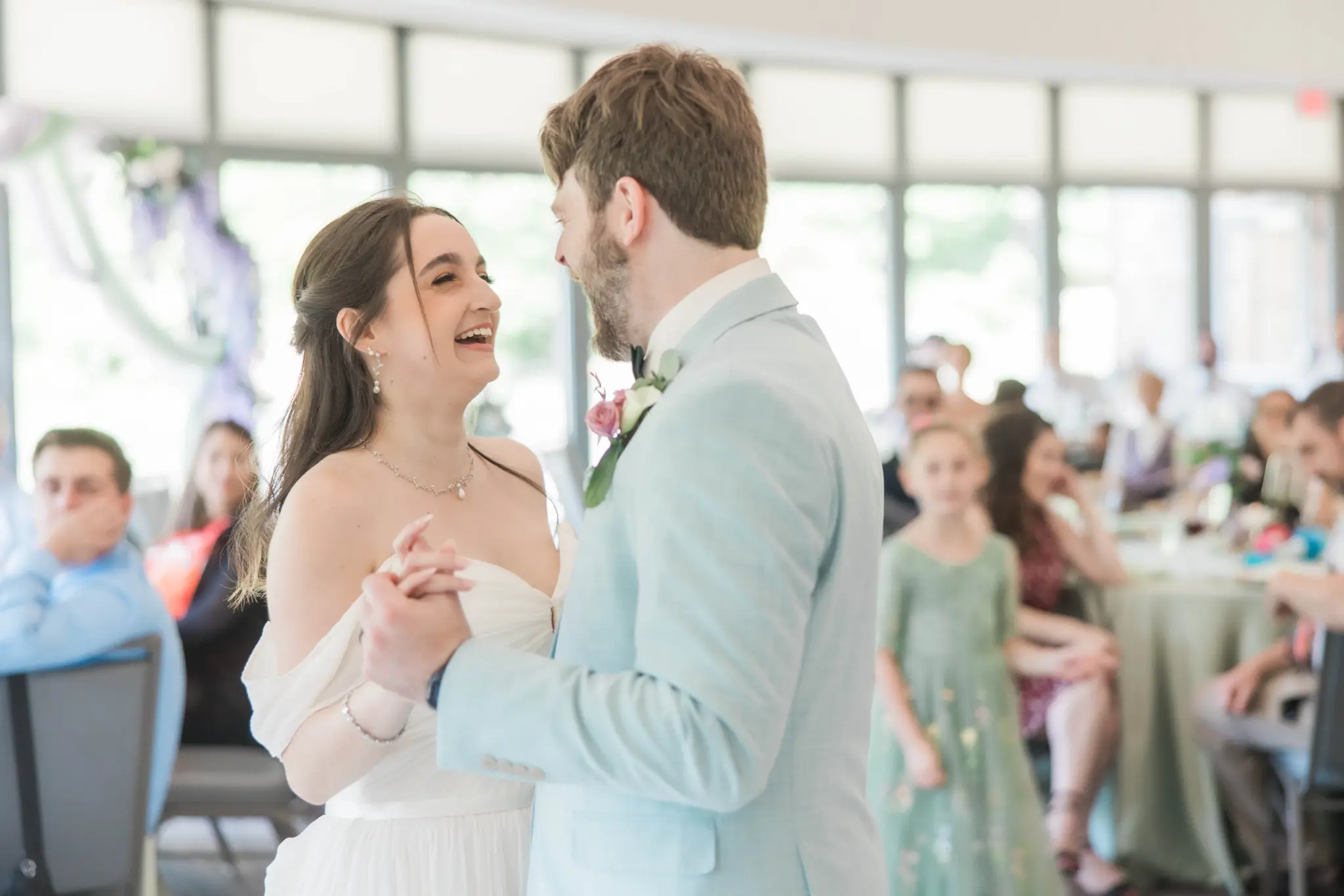Photo of a bride and a groom dancing at a wedding for first dance wedding songs;.