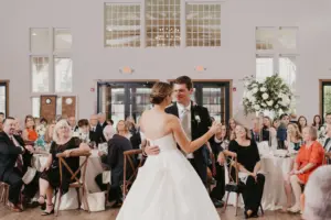 Photo of a couple slow dancing at a wedding while the guests watch for first dance wedding songs.