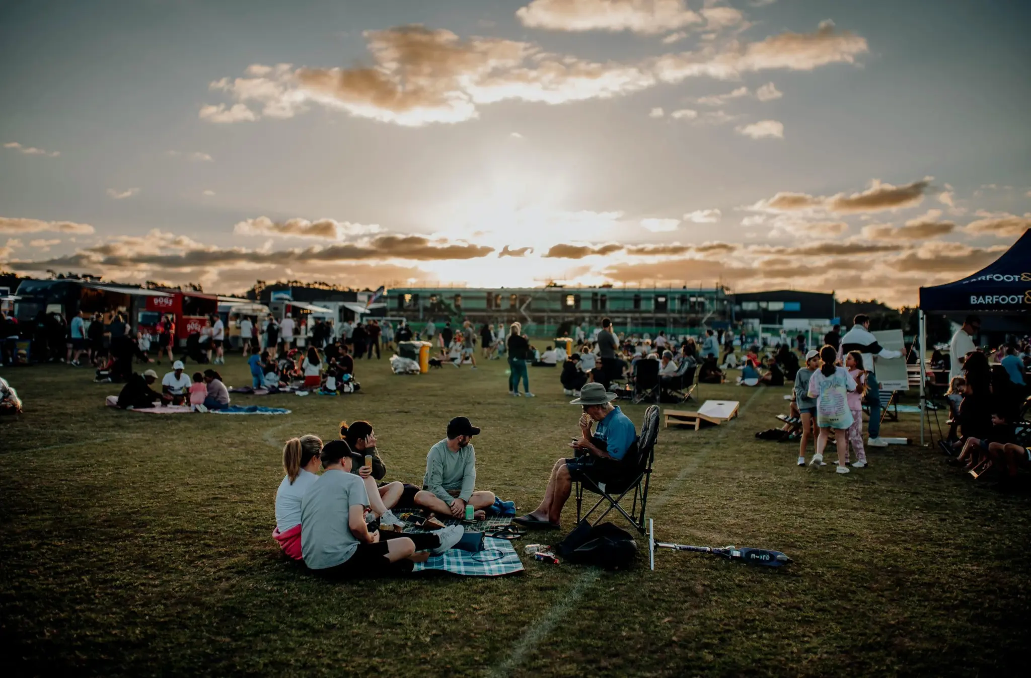 Photo of an outdoor festival in a park with food trucks.