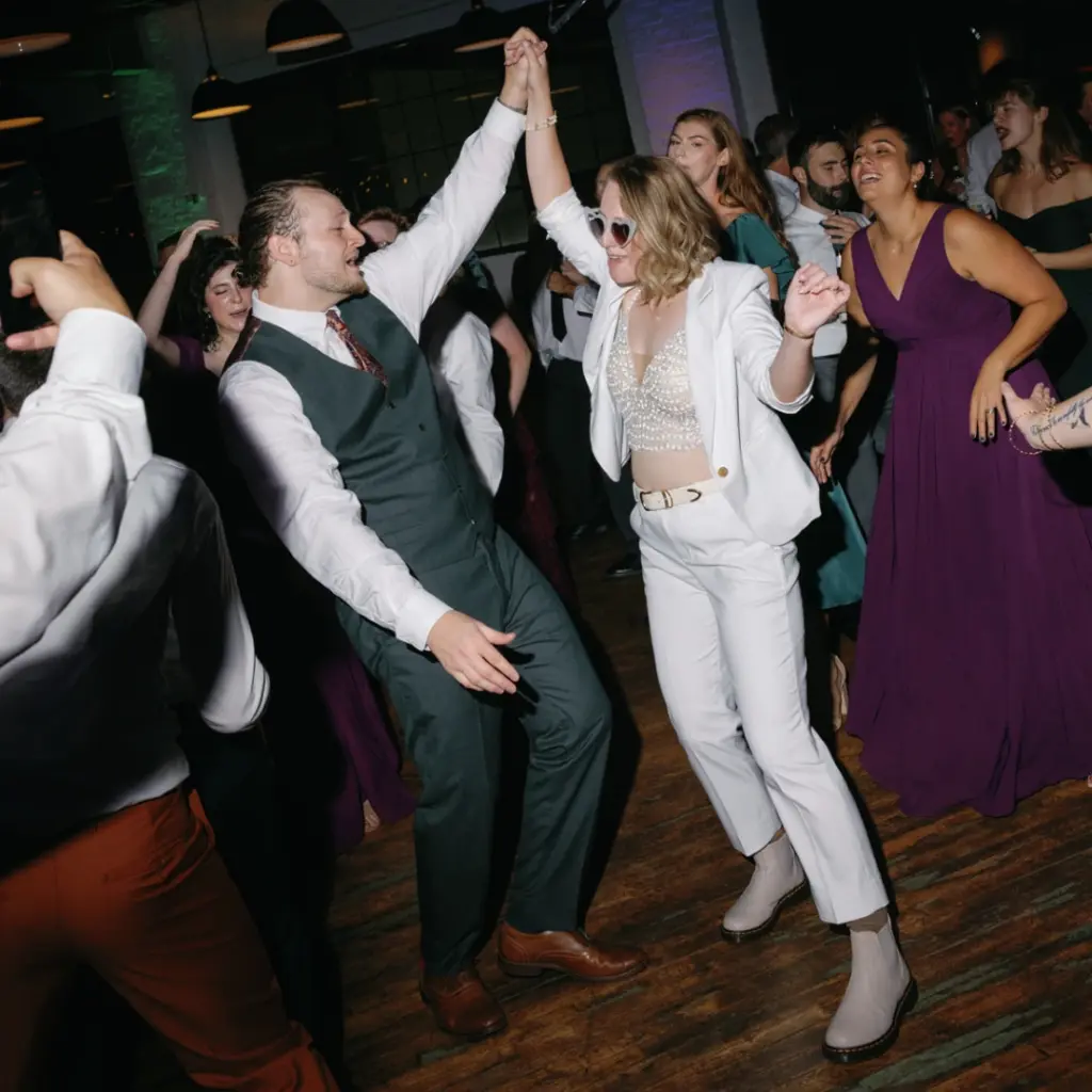Photo of a bride and groom dancing with their guests for wedding games