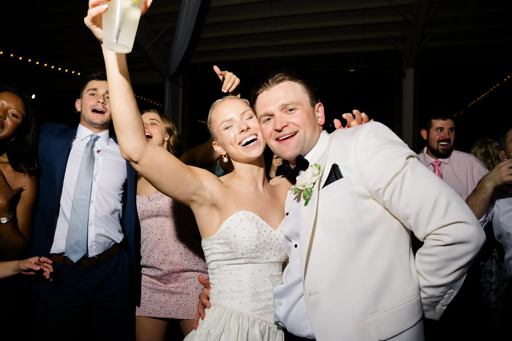 photo of a bride and groom smiling among their guests for wedding games