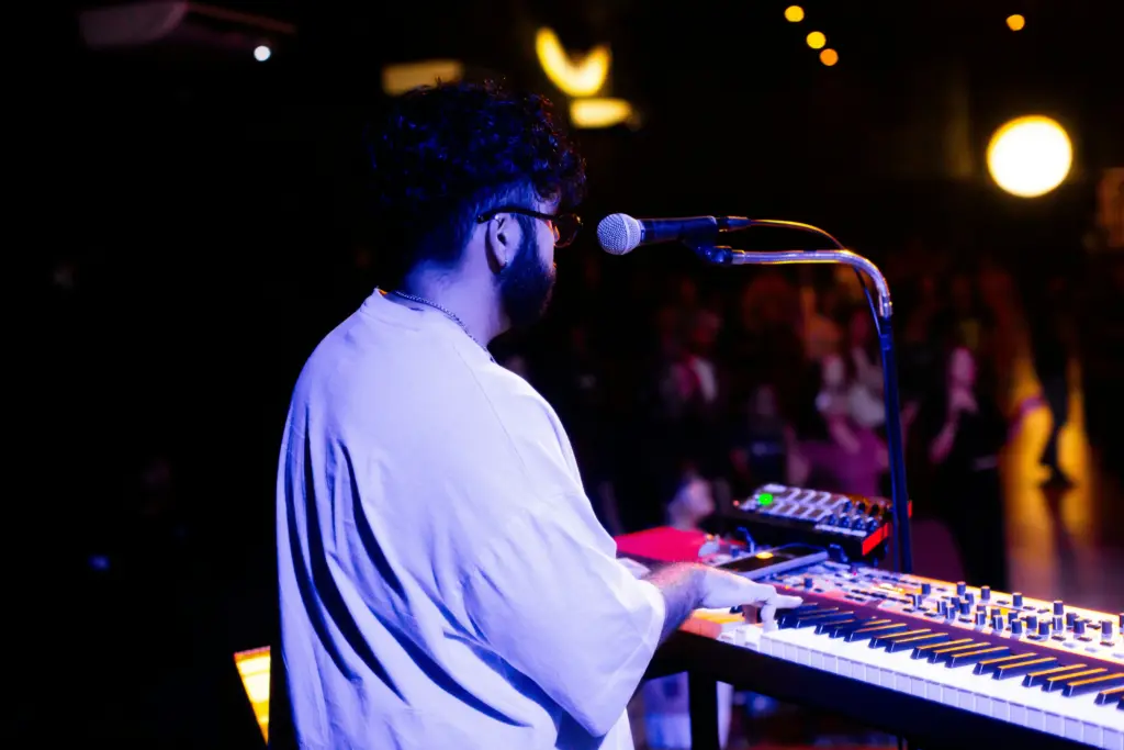 photo-of-a-man-playing-the-keyboard-at-an-event-with-a-mic