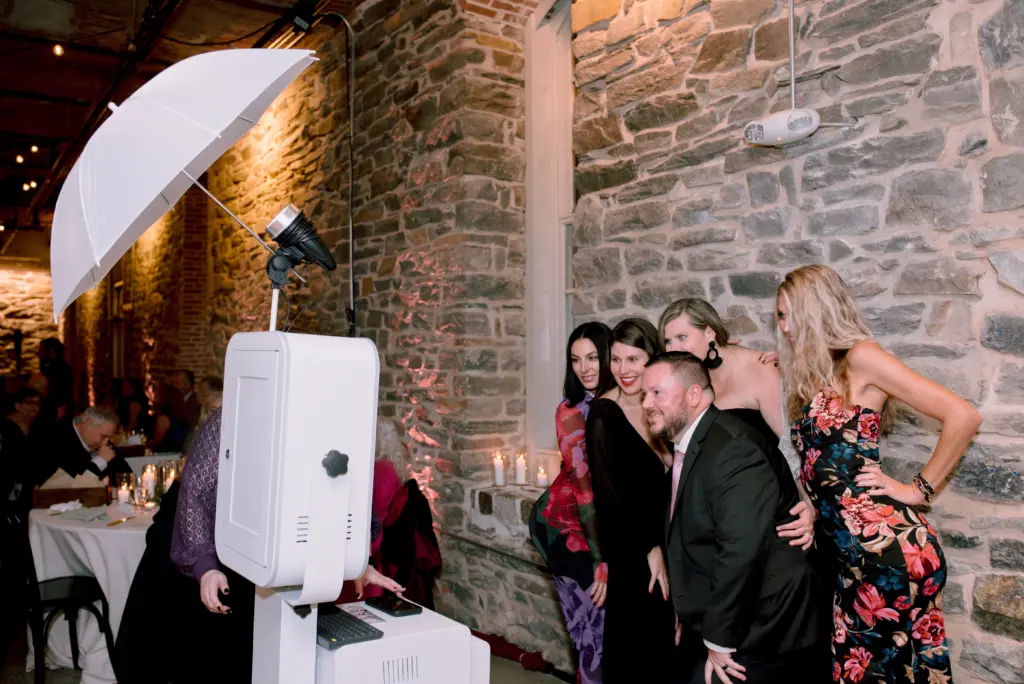 photo of guests posing in front of a photo booth for how much is a photo booth rental