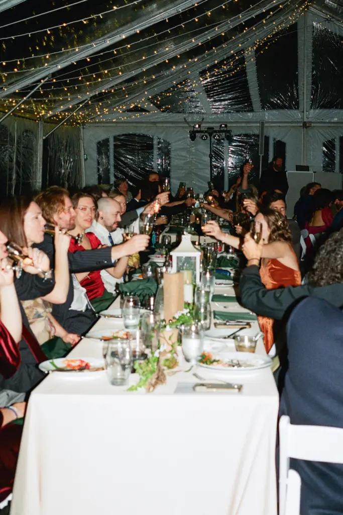 photo of wedding guests having dinner at a long table for how to choose a wedding venue