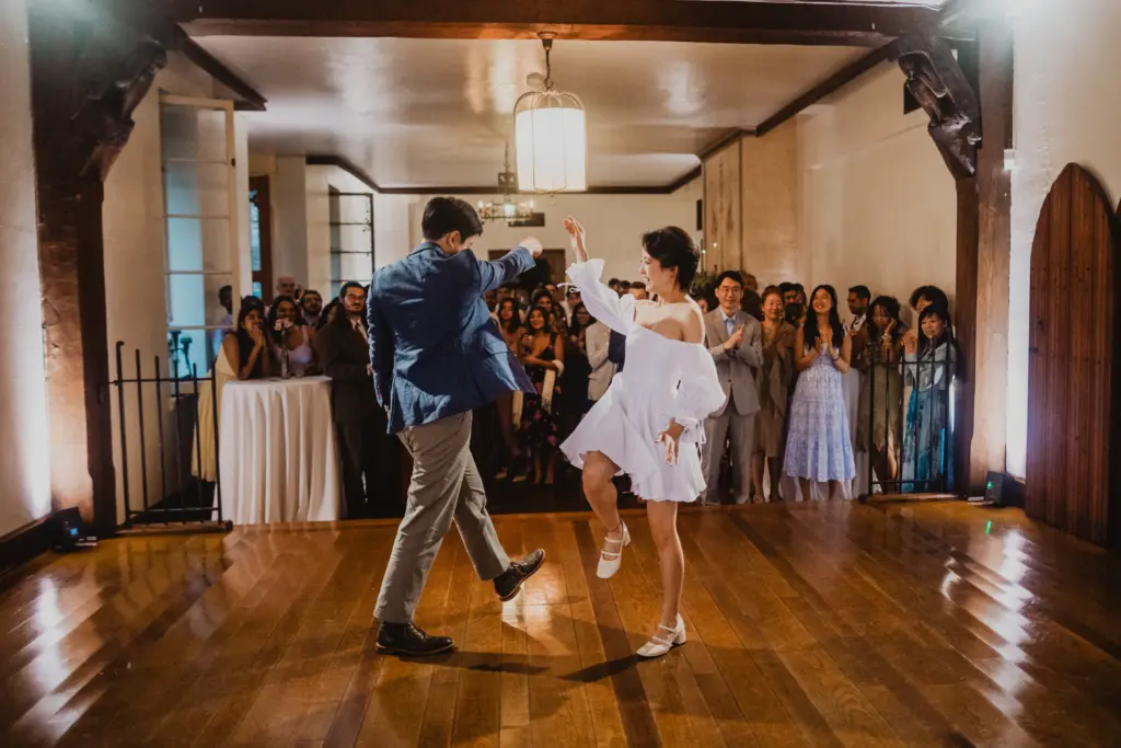 photo-of-a-couple-dancing-on-wooden-flooring-while-the-guests-are-clapping