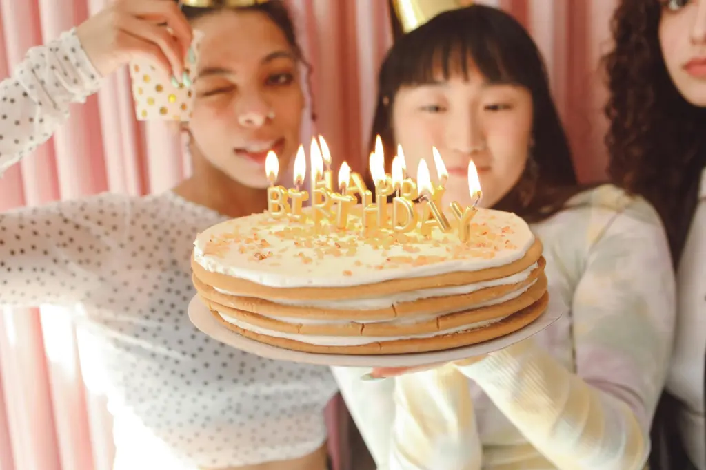 photo-of-three-girls-holding-up-a-cake-with-lit-candles-spelling-happy-birthday-for-birthday-party-ideas-for-teenagers