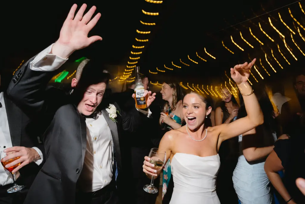photo of a couple dancing at a wedding with uphead lightings and drinks in their hands