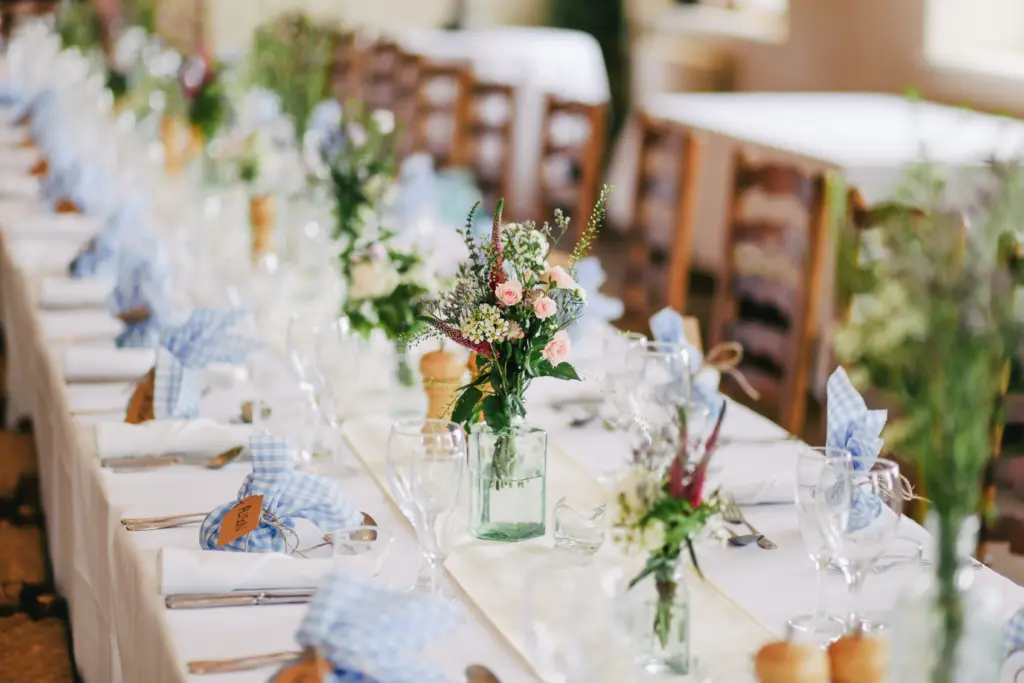 photo of table decorations with vases with flowers plates cutlery and napkins