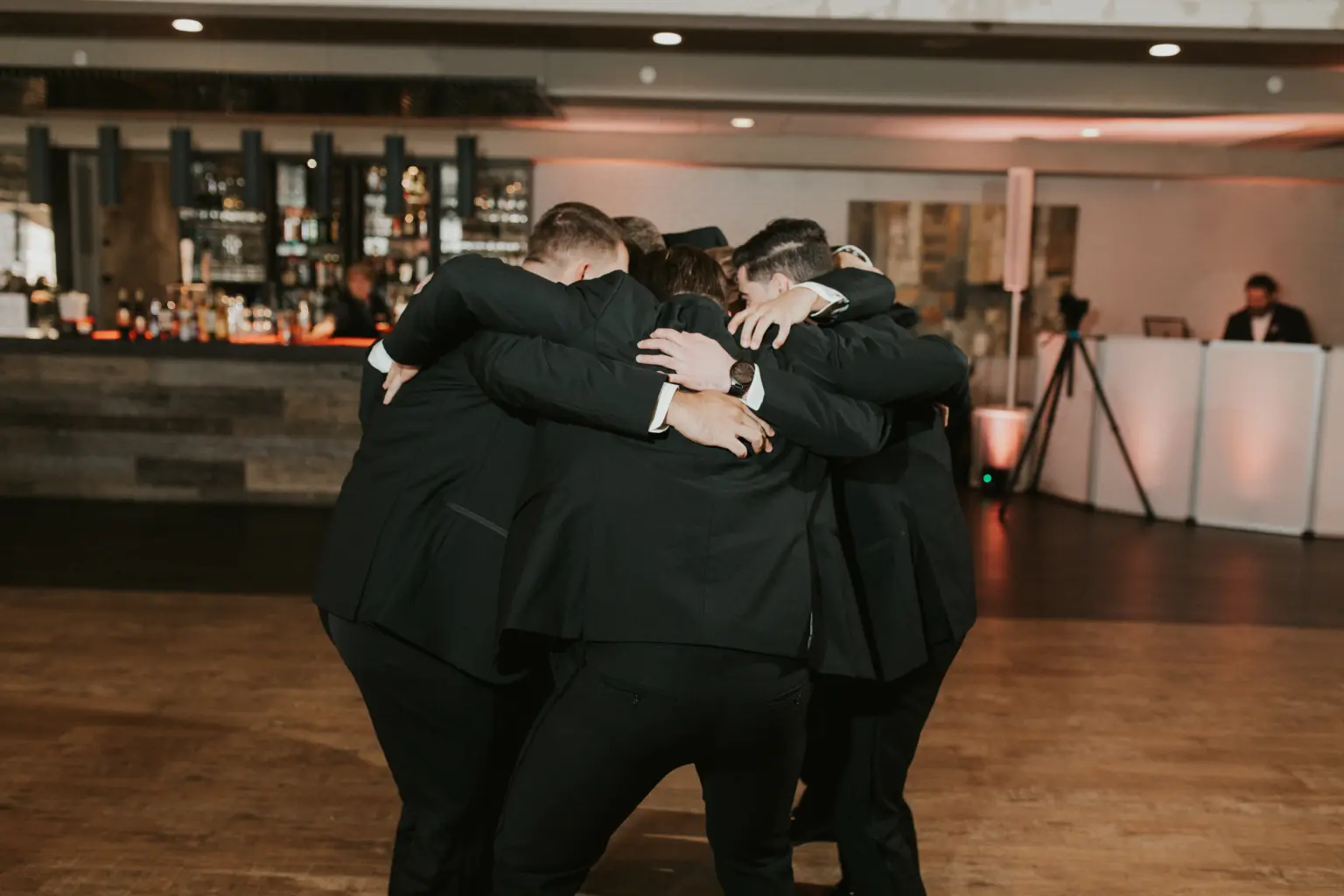 photo of a bride and groom at their wedding venue with their guests standing and clapping for them