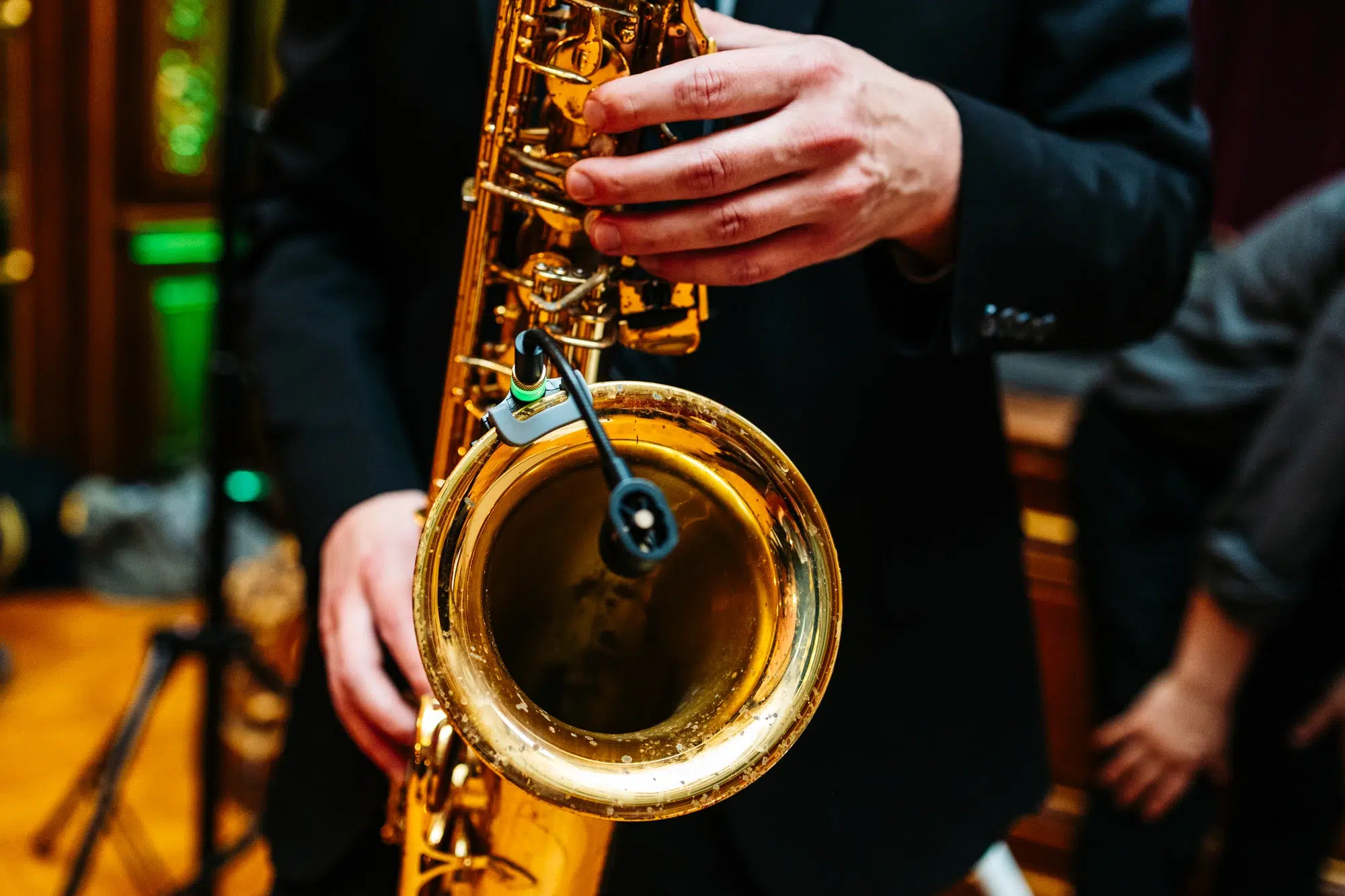 photo of a man playing a saxophone with a mic attached to it