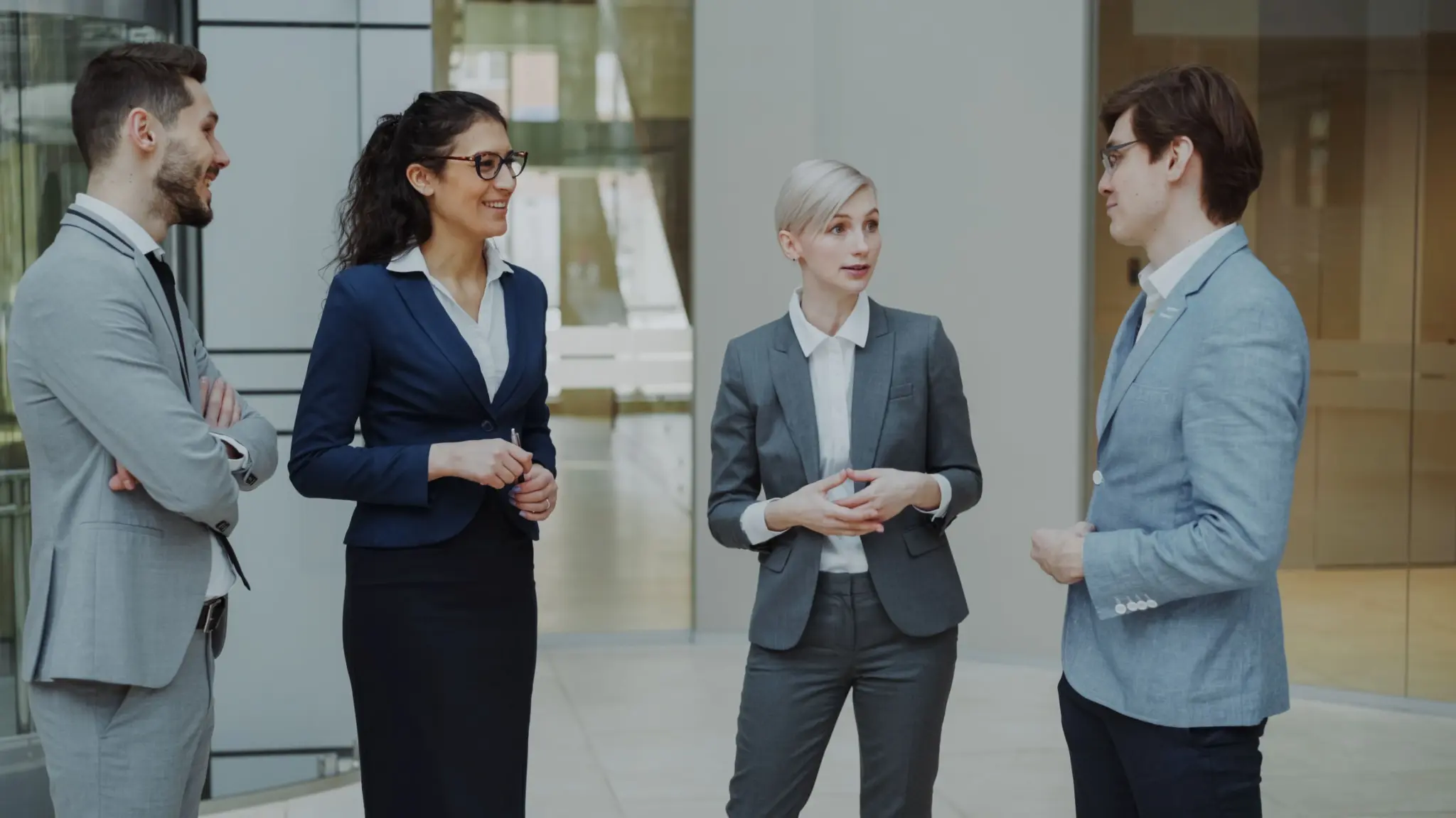 photo-of-four-people-in-suits-talking-at-a-networking-event
