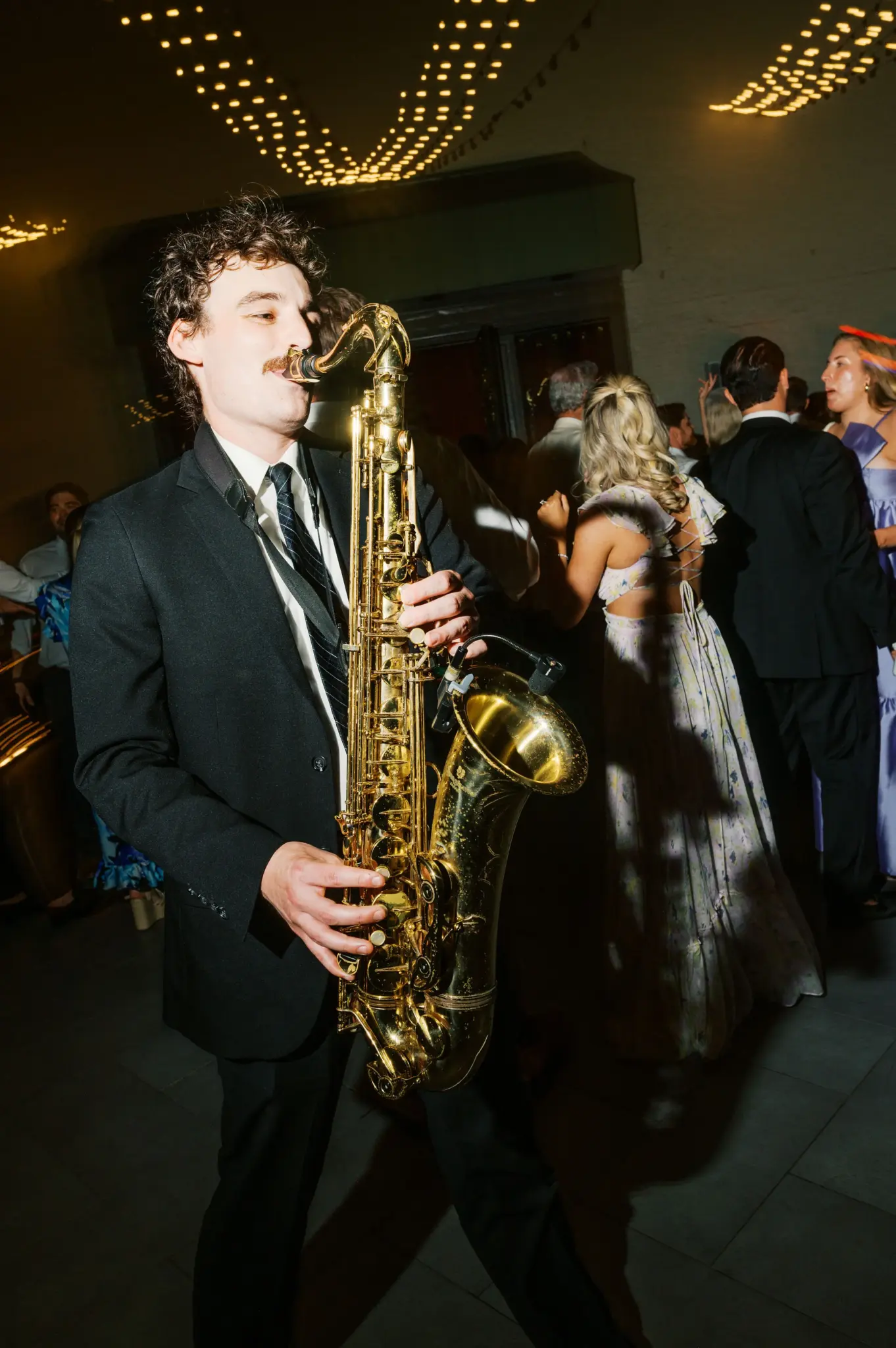 photo saxophonist performing on dance floor at wedding reception