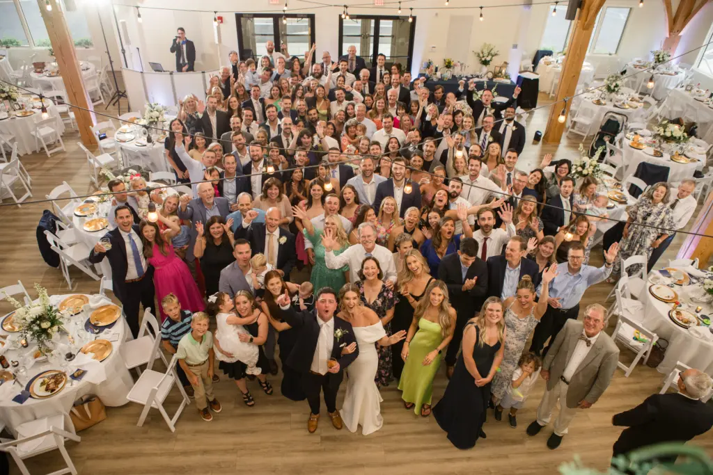 photo of all the guests standing behind the bride and groom top view
