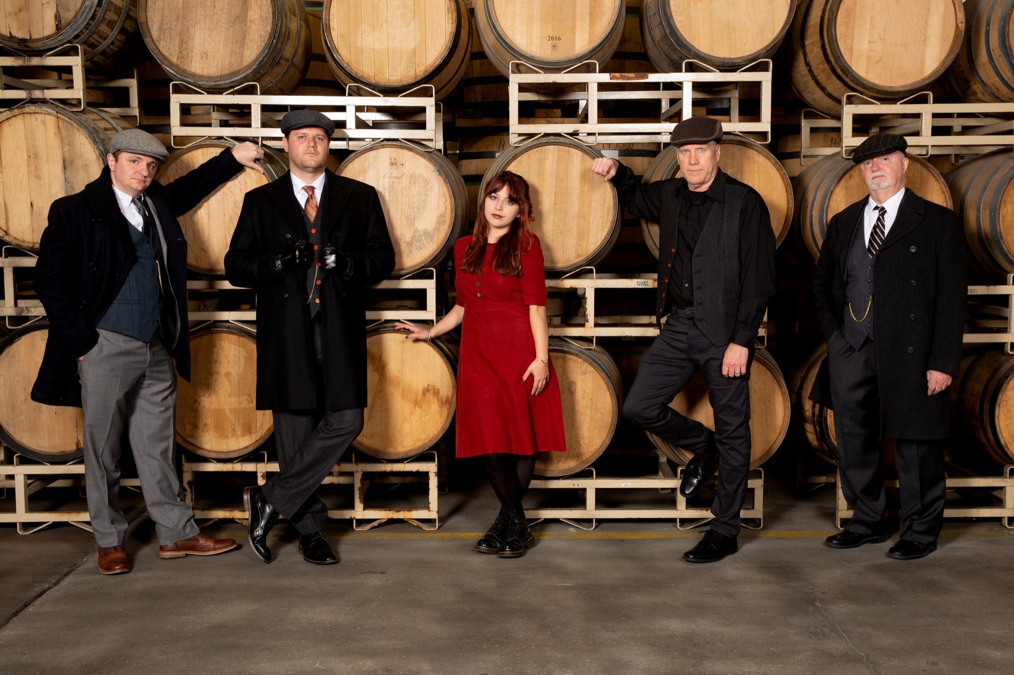 Band in costume posing among barrels at Guinness Open Gate Brewery