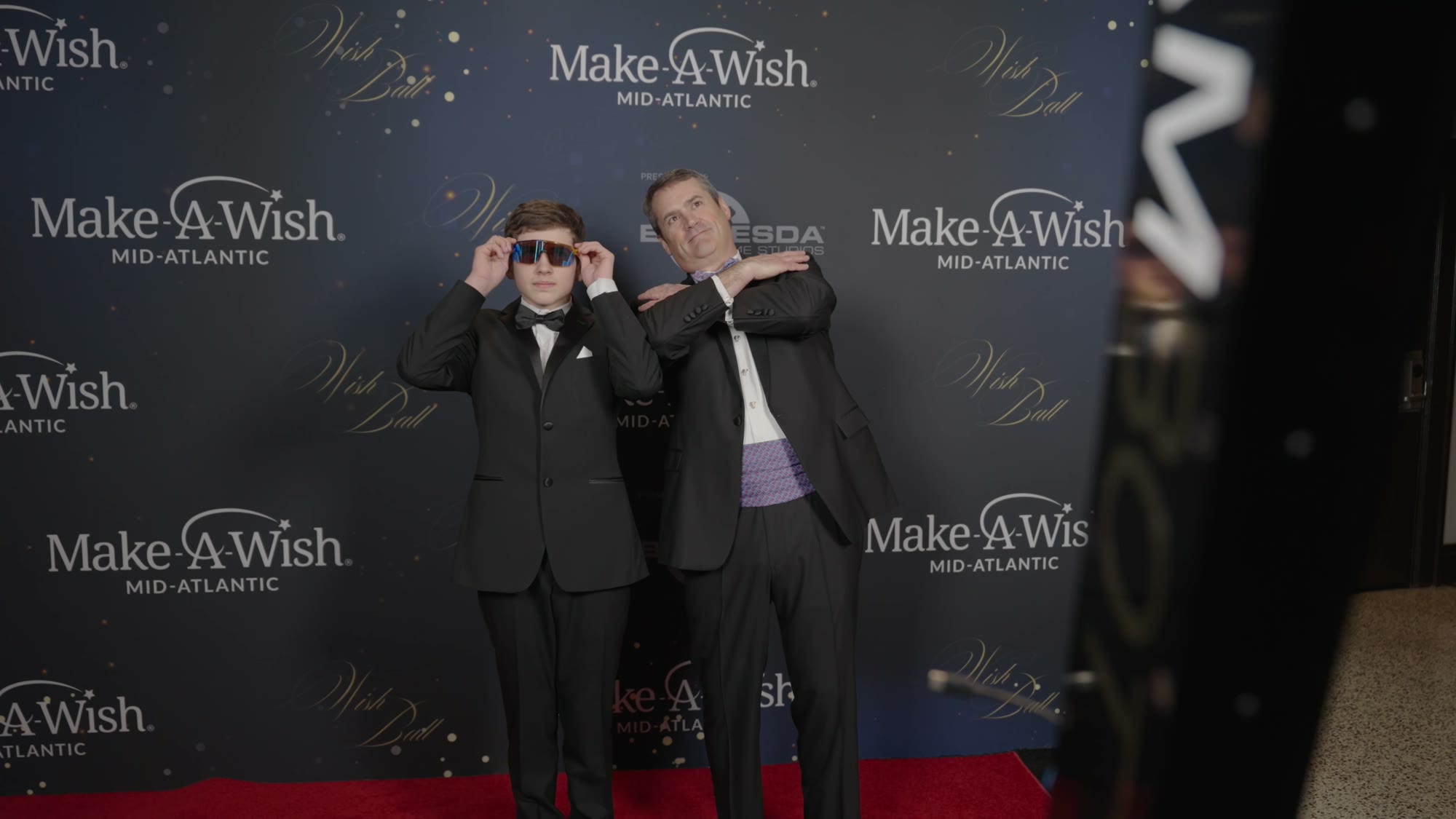 Guests in sunglasses posing for the Glambot at the Make-A-Wish gala