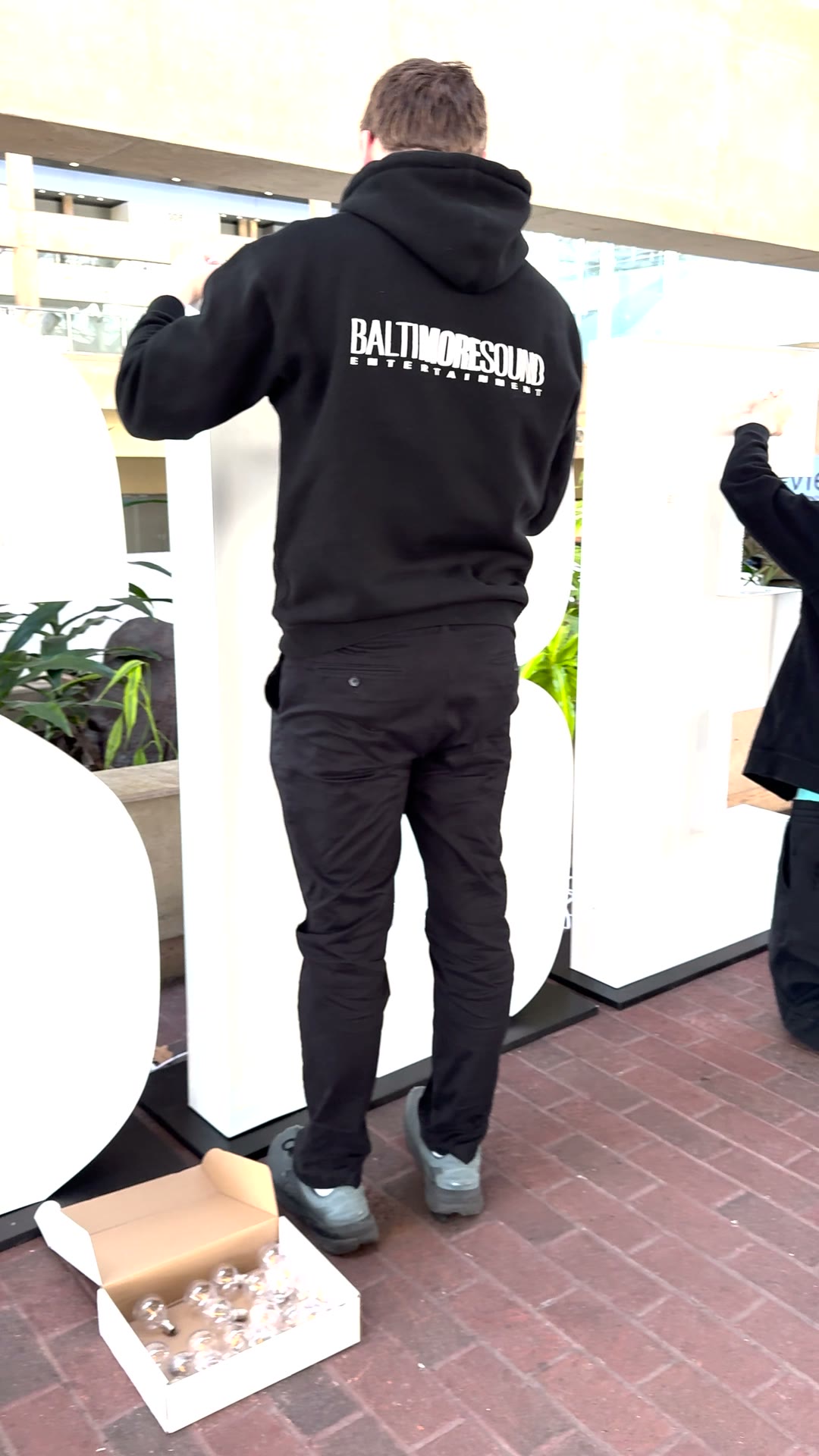BSE crew member in a Baltimore Sound Entertainment hoodie fitting bulbs into the NSBE letters