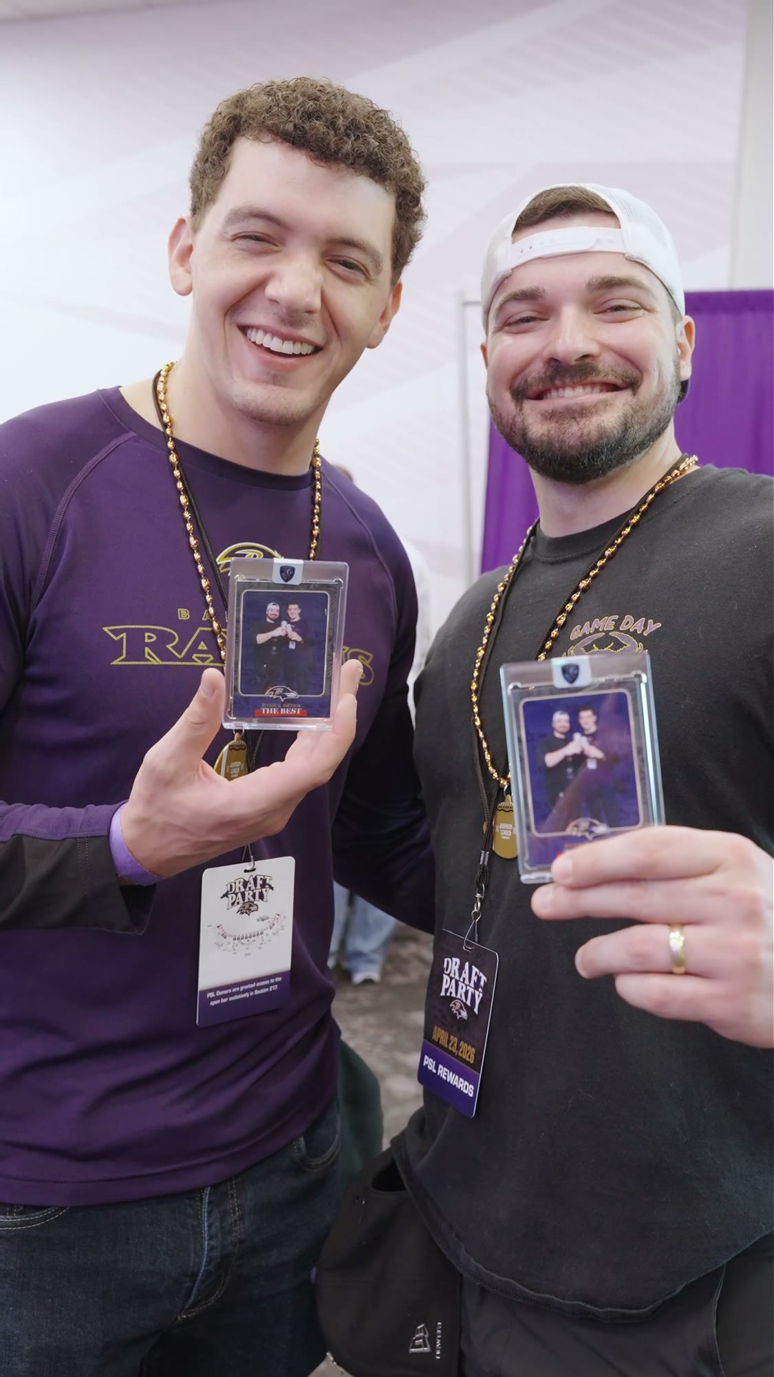 Two fans showing their custom Ravens trading cards